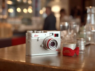 a leica leitz camera on a table in a coffee shop --s 209 --c 51 --ar 4:3 --style raw --v 5.1